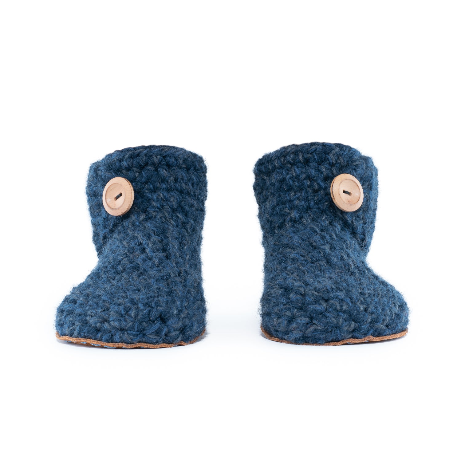 Floris x KOW slippers. A pair of midnight blue crocheted slippers with leather soles on a white background. Front view.