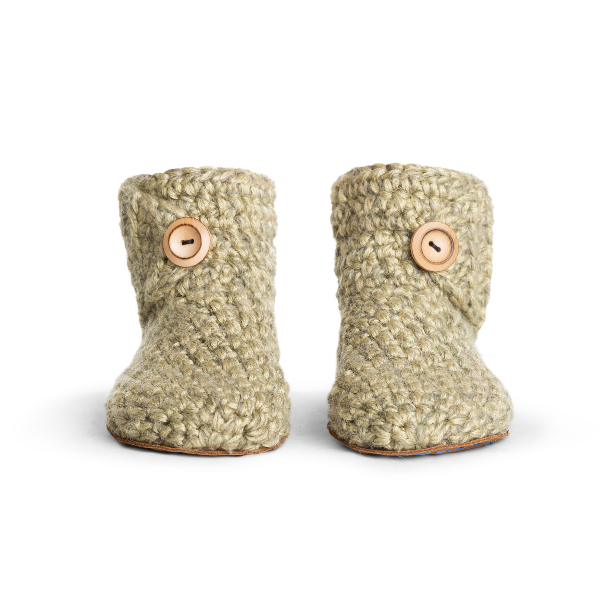 Floris x KOW slippers. A pair of winter moss green crocheted slippers with leather soles on a white background. Front view.