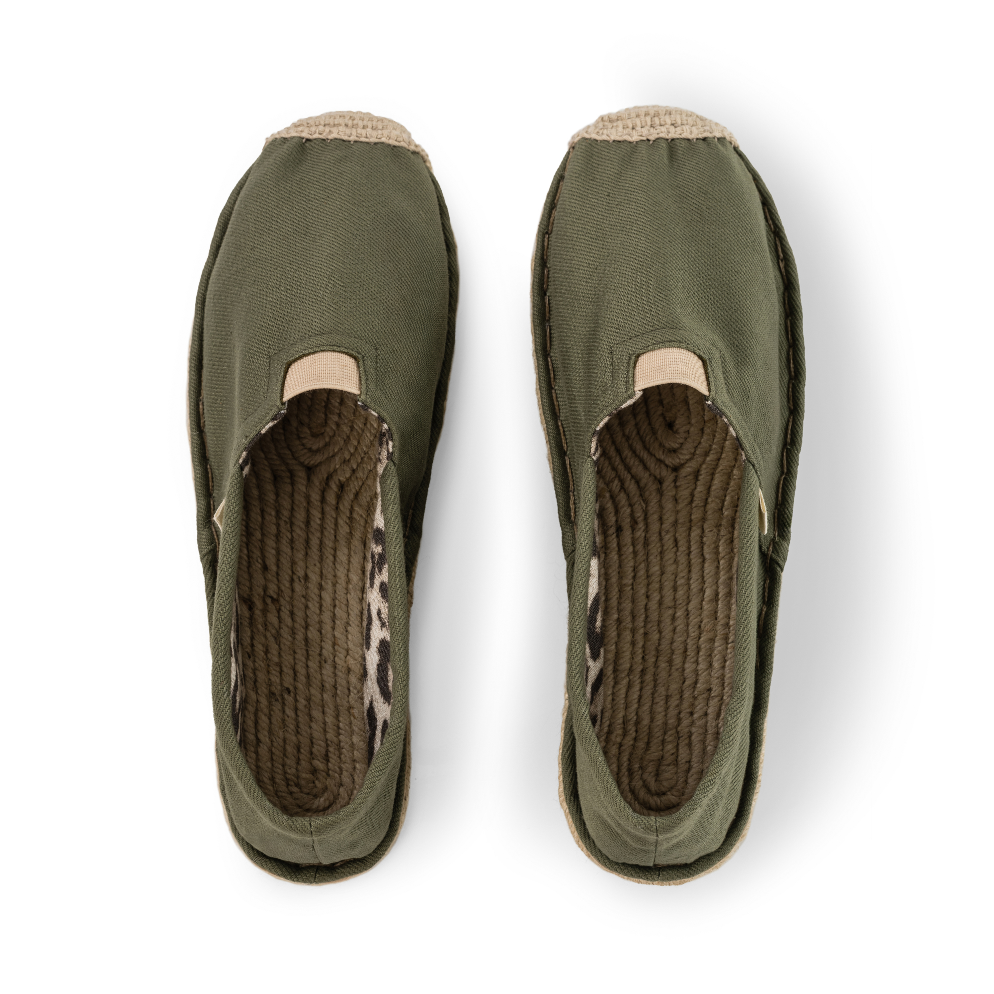 Pair of olive green slip-on shoes with leopard print inner and jute soles on a white background