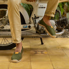 Man wearing khaki green espadrilles sat on a motorcycle