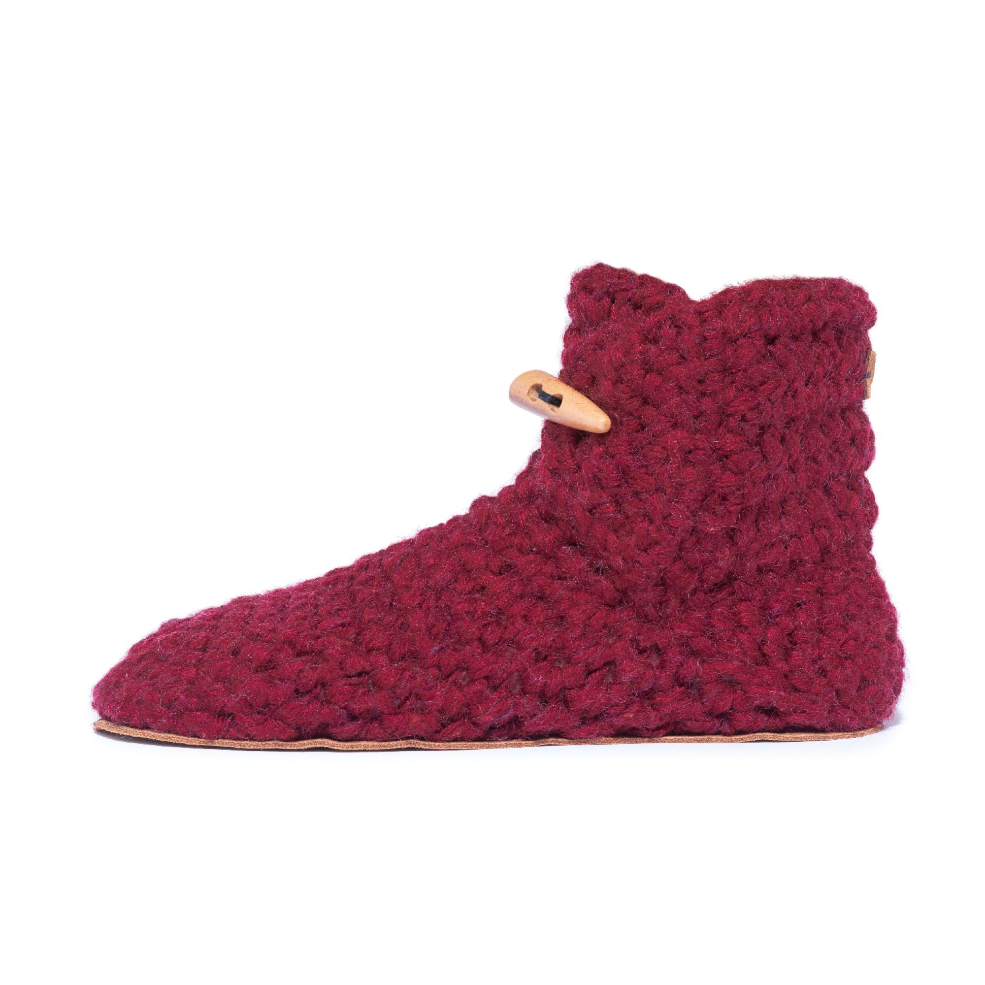 Red knitted slipper with a wooden button on a white background