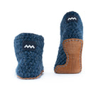 Floris x KOW slippers. A pair of midnight blue crocheted slippers with leather soles on a white background. Back view.