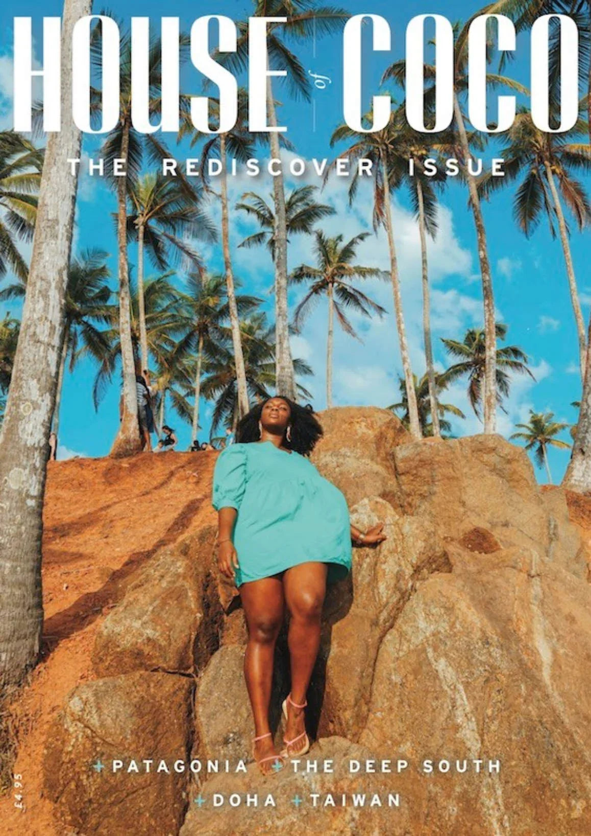 Magazine cover with a woman on a rocky outcrop surrounded by palm trees, featuring 'House of Coco' and travel destinations.