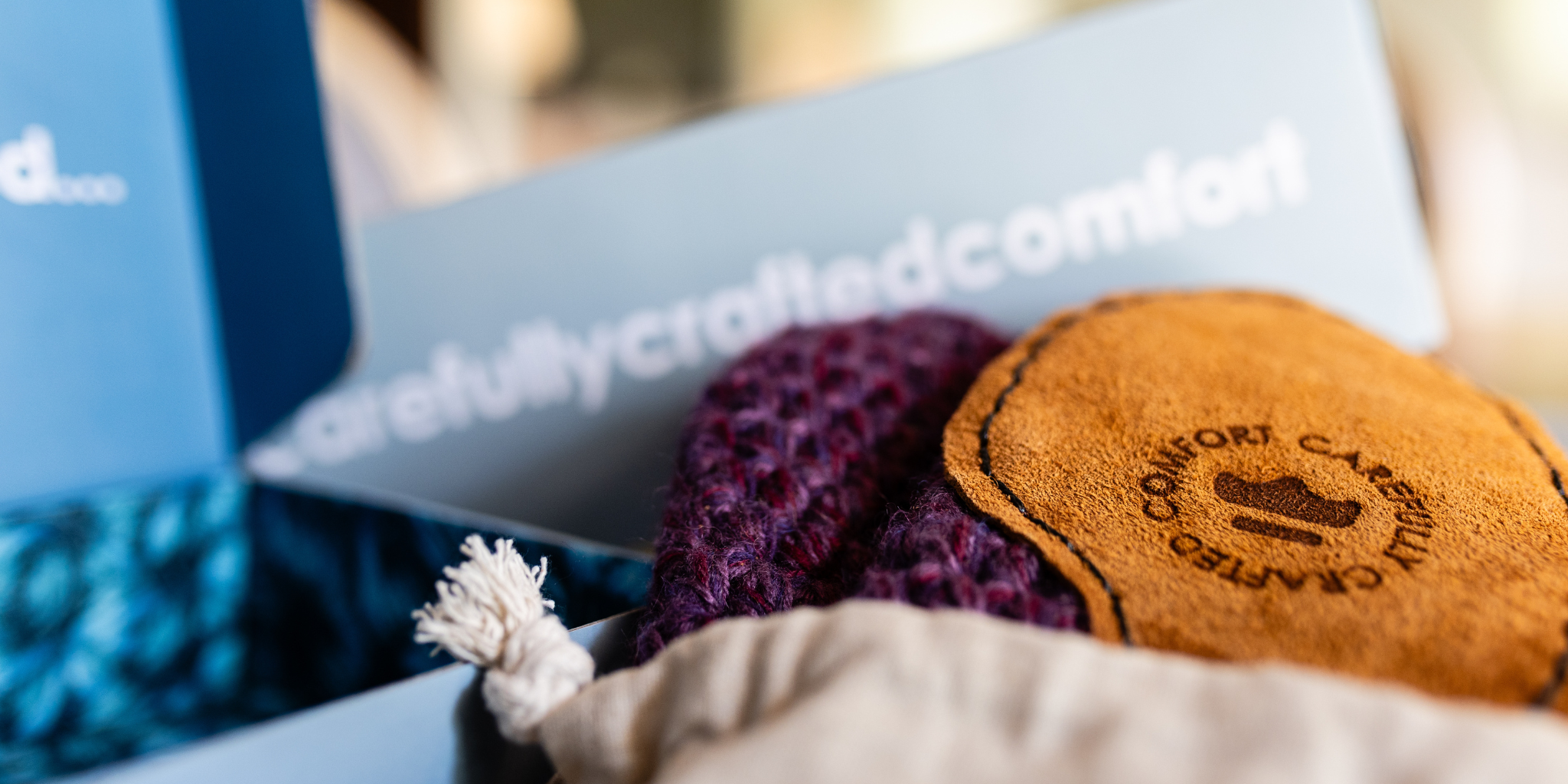 Slippers with a branded box featuring 'Carefully Cycled Comfort' text.