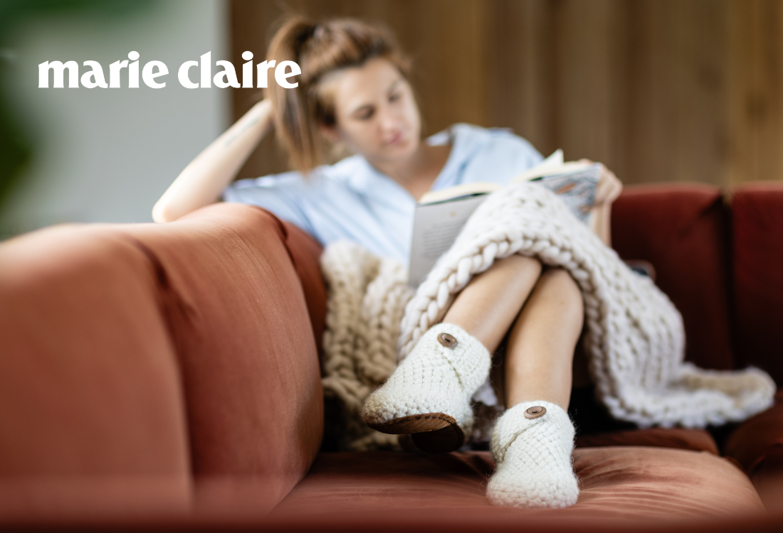 Woman reading a book on a couch with 'Marie Claire' branding.