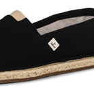 Close up of a black espadrille shoe by KOW on a white background