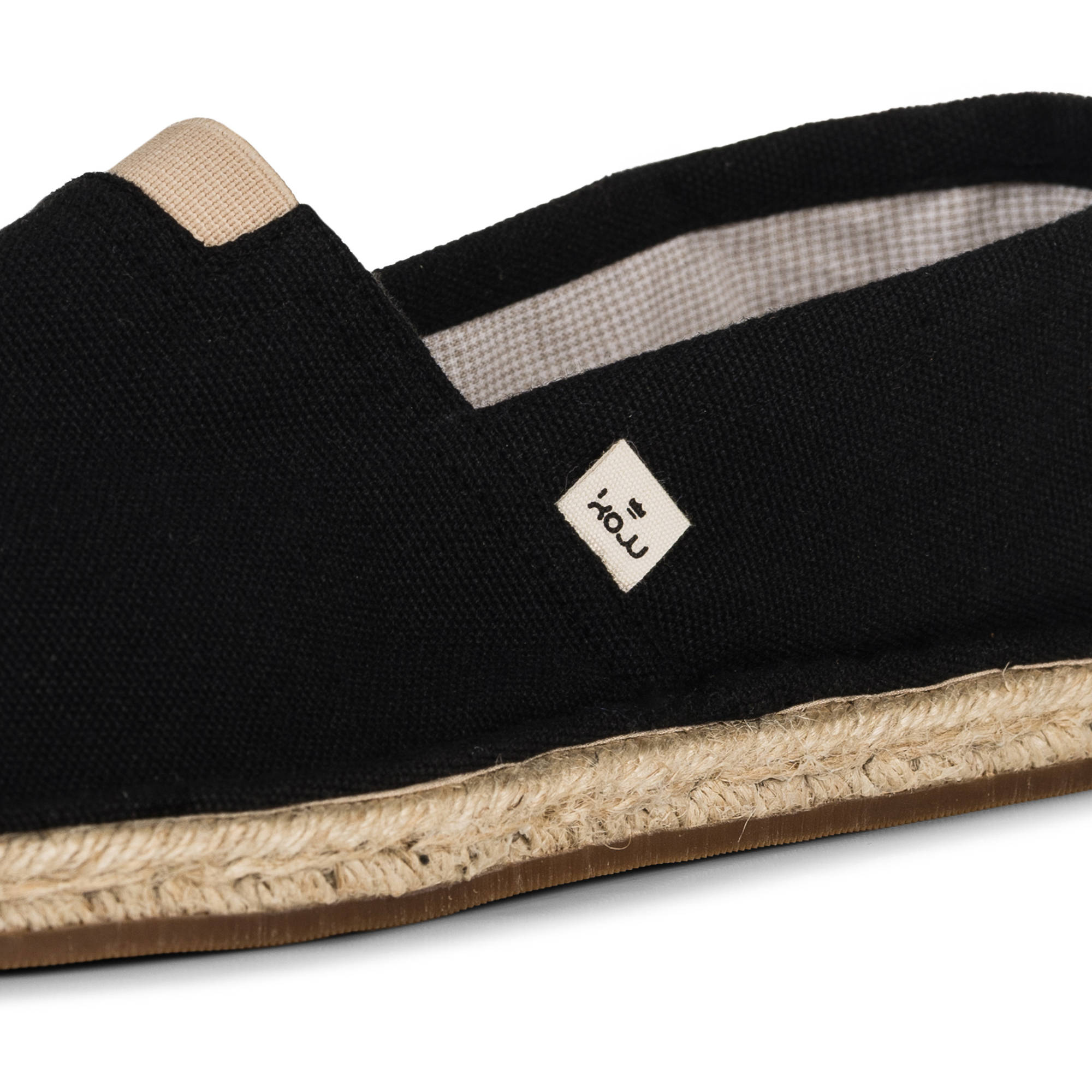 Close up of a black espadrille shoe by KOW on a white background