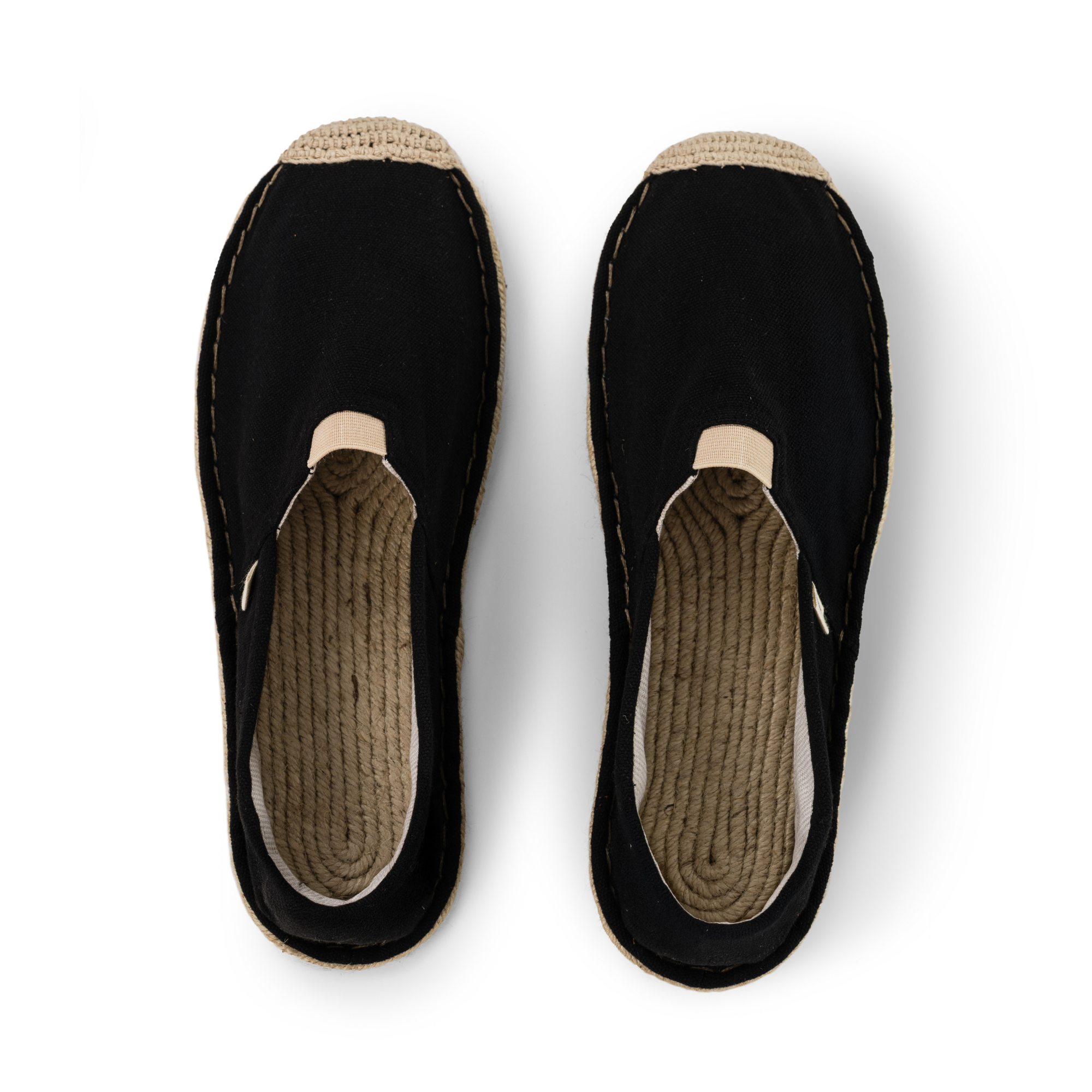Pair of black slip-on espadrilles with jute soles on a white background