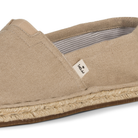 Clsoe up of beige espadrille shoe with KOW brand label on a white background