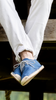 Man wearing blue lace up espadrilles walking on a balcony