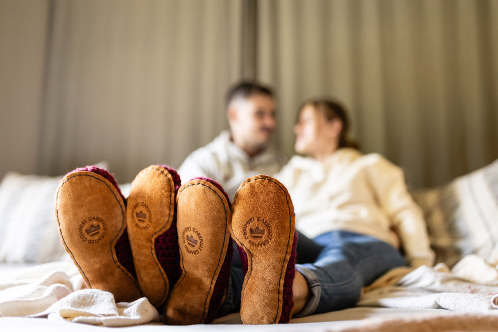 Blurred image of couple in bed, Kingdom of Wow Slipper Soles focused in foreground