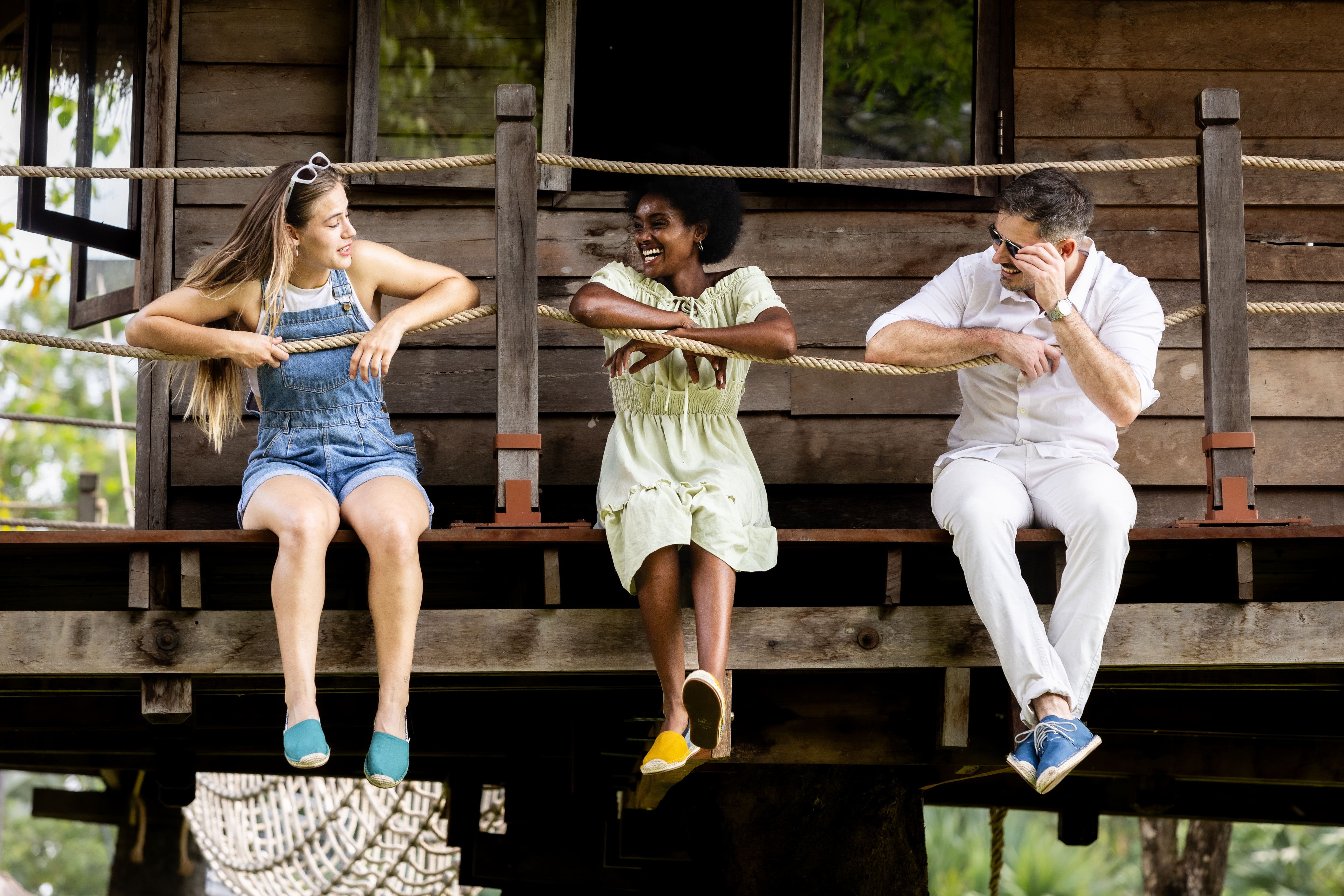 Three friends hanging legs off a tree house whilst wearing Kingdom of Wow Espadrilles