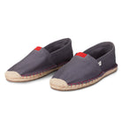 Pair of gray espadrilles with red accents on a white background