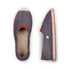 Gray espadrille shoes with red accents on a white background